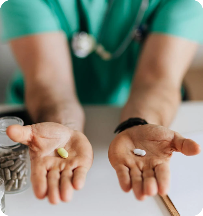 A healthcare professional presenting two pills, highlighting their role in medical therapy.