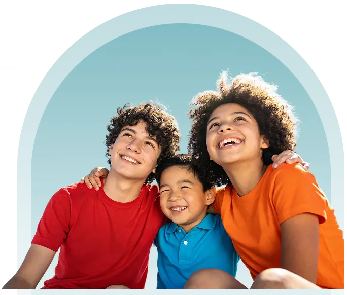 A young boy engaged with a laptop at a table, displaying concentration and curiosity.