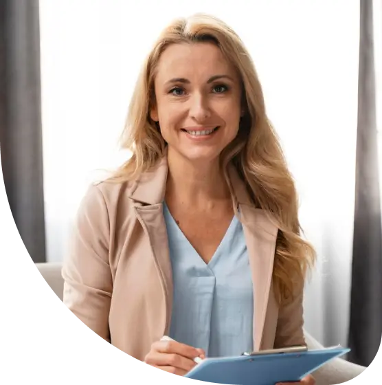 A woman seated on a couch, engaged with a tablet in her hands, focused and relaxed in her environment.