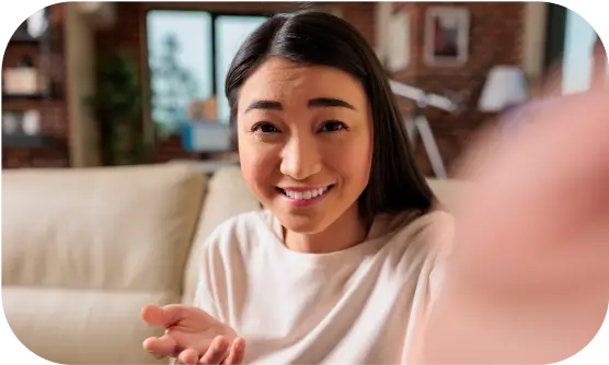 A woman with a joyful expression sits comfortably on a couch, radiating warmth and happiness.