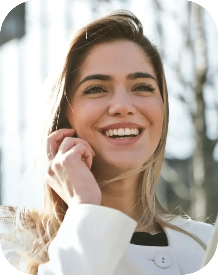 A woman smiles while holding a tablet computer, showcasing a positive and engaging expression.