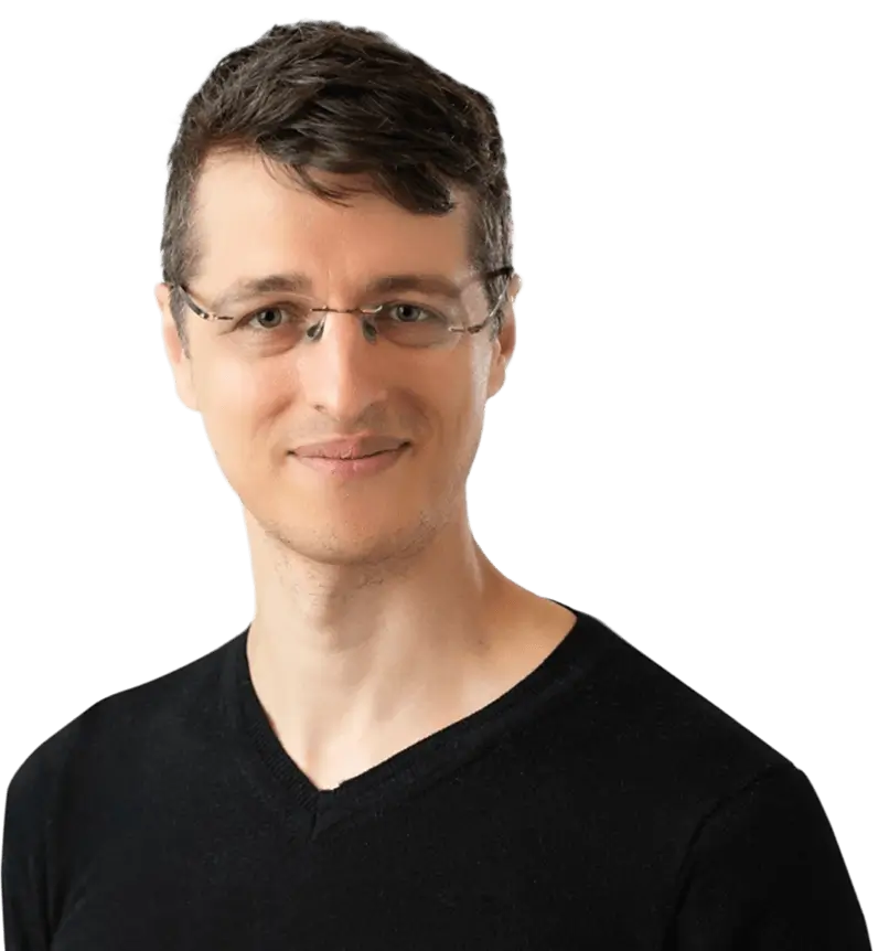 A man wearing glasses and a black shirt, looking directly at the camera with a neutral expression.