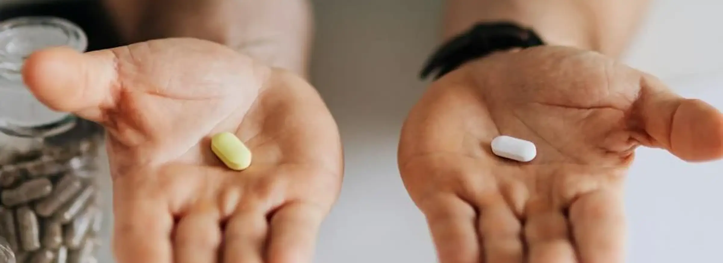 A healthcare professional presenting two pills, highlighting their role in medical therapy.